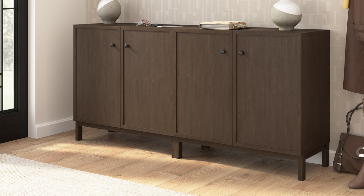 Dark wood sideboard with decorative items in a room with framed pictures on the wall.